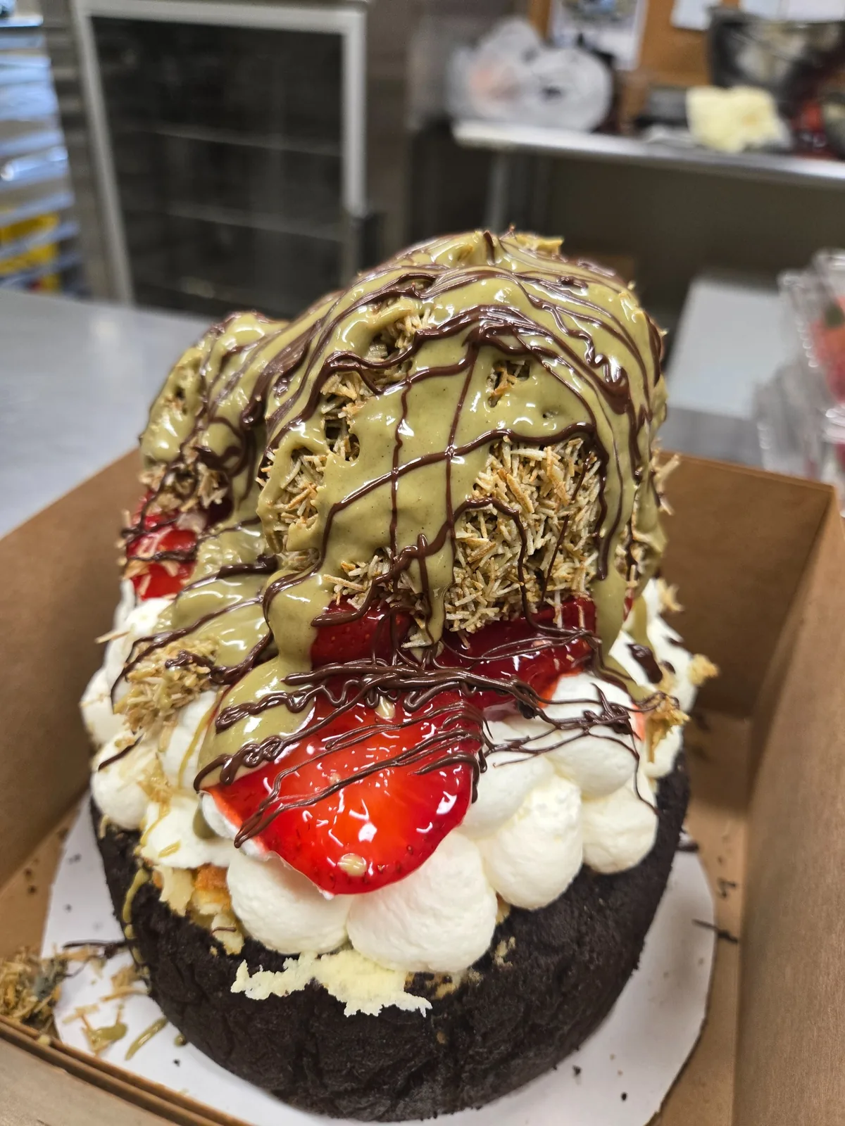 An elaborate whole Josef's cheesecake with strawberries and pistachio topping